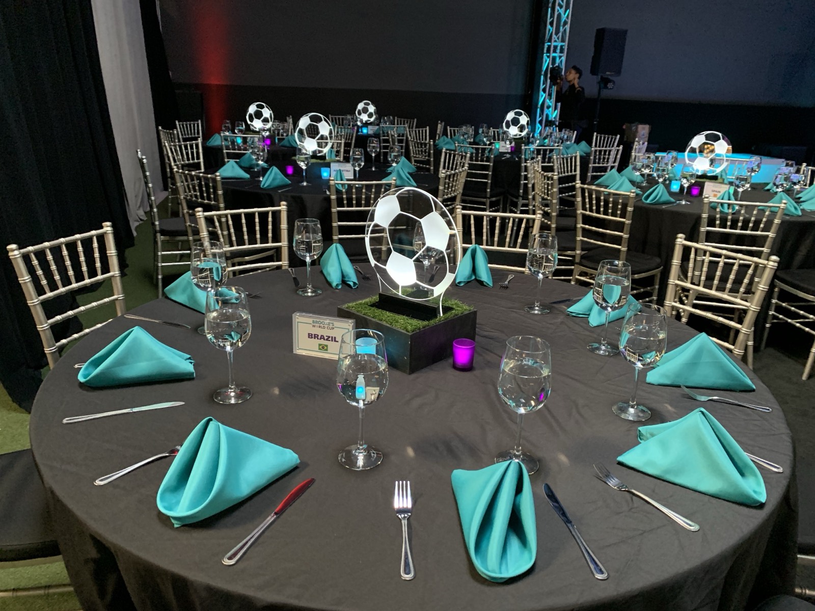 World Cup–themed private celebration produced by Rental Setups, with soccer-ball centerpieces and teal table settings